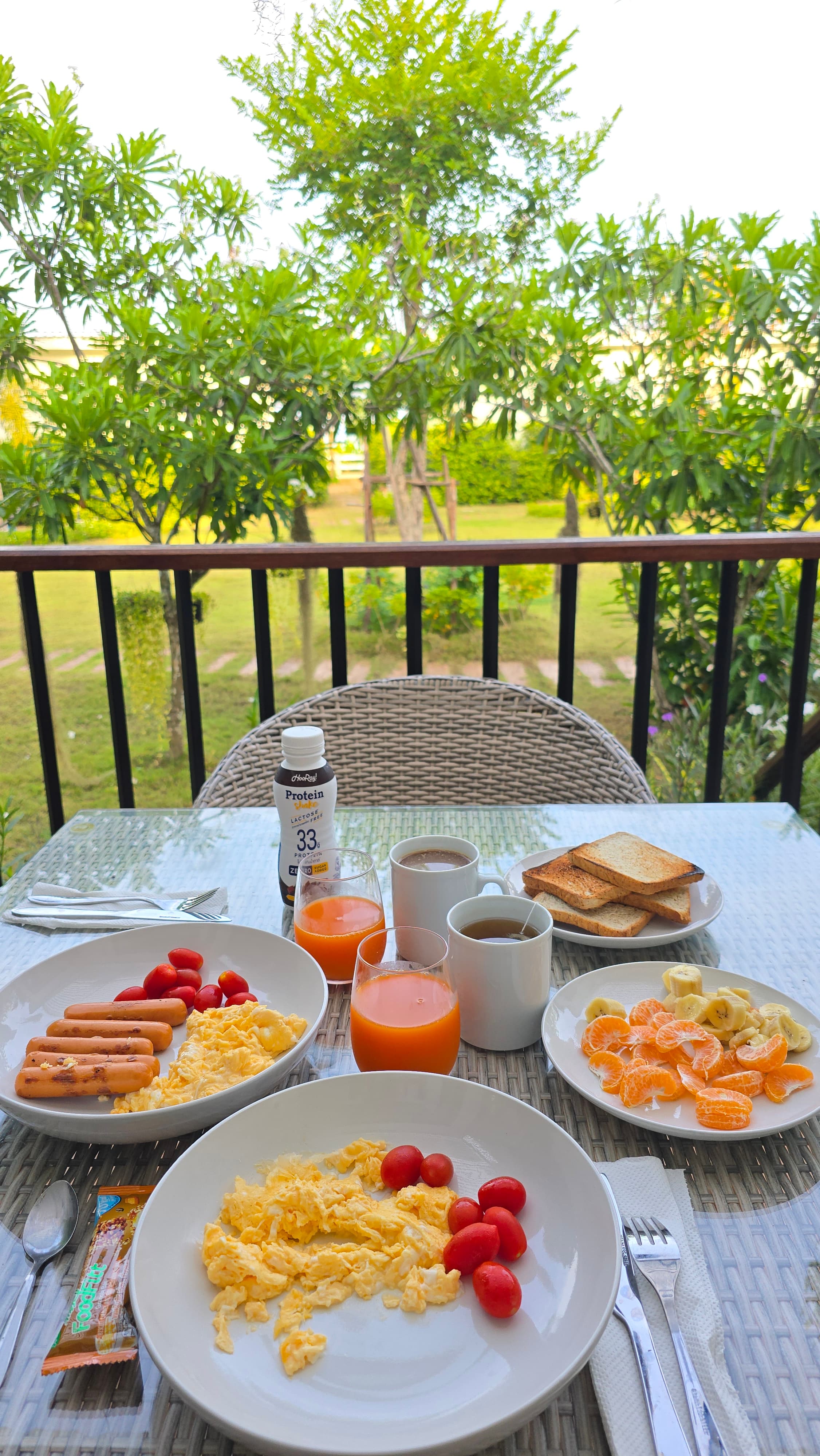 Balcony breakfast spread with tropical garden views — Caya Beach by Satori