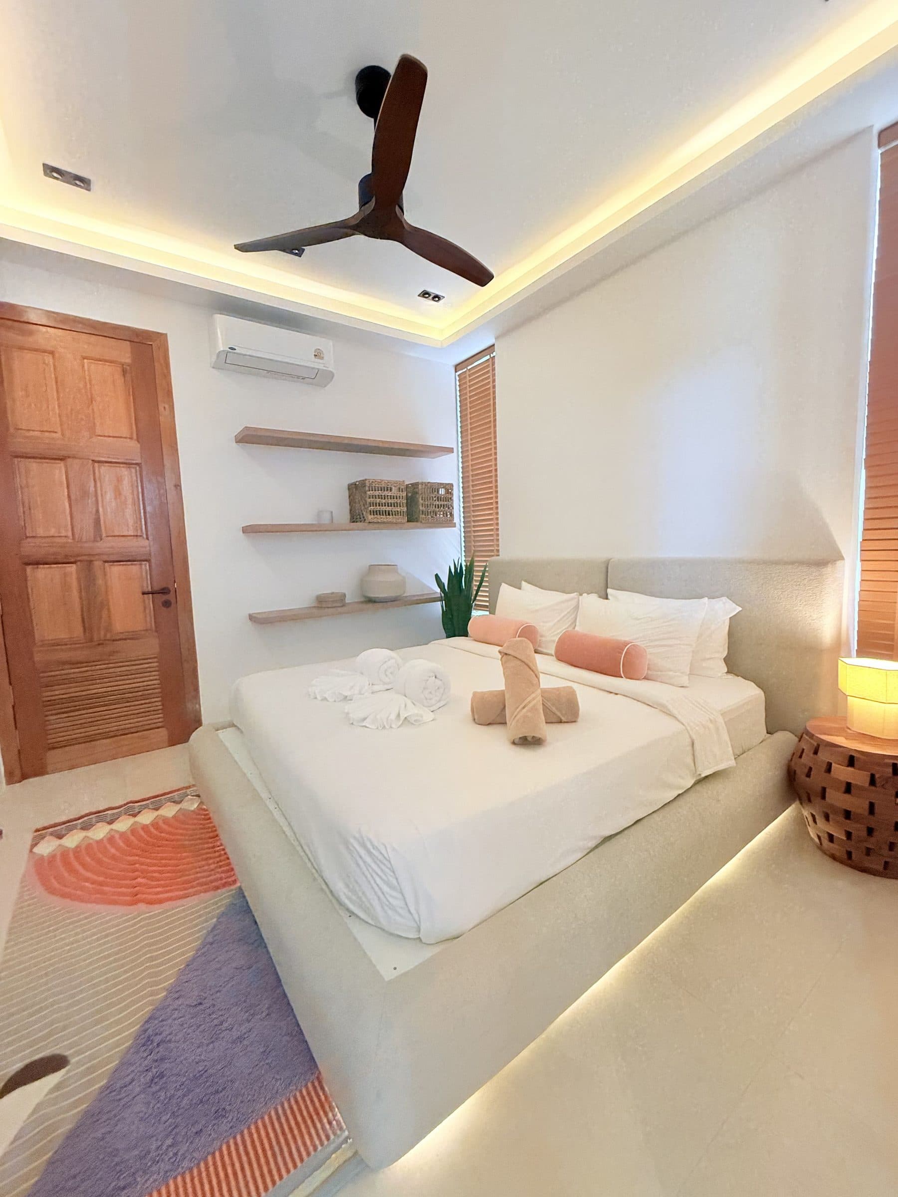 Queen bedroom with shelving and ceiling fan