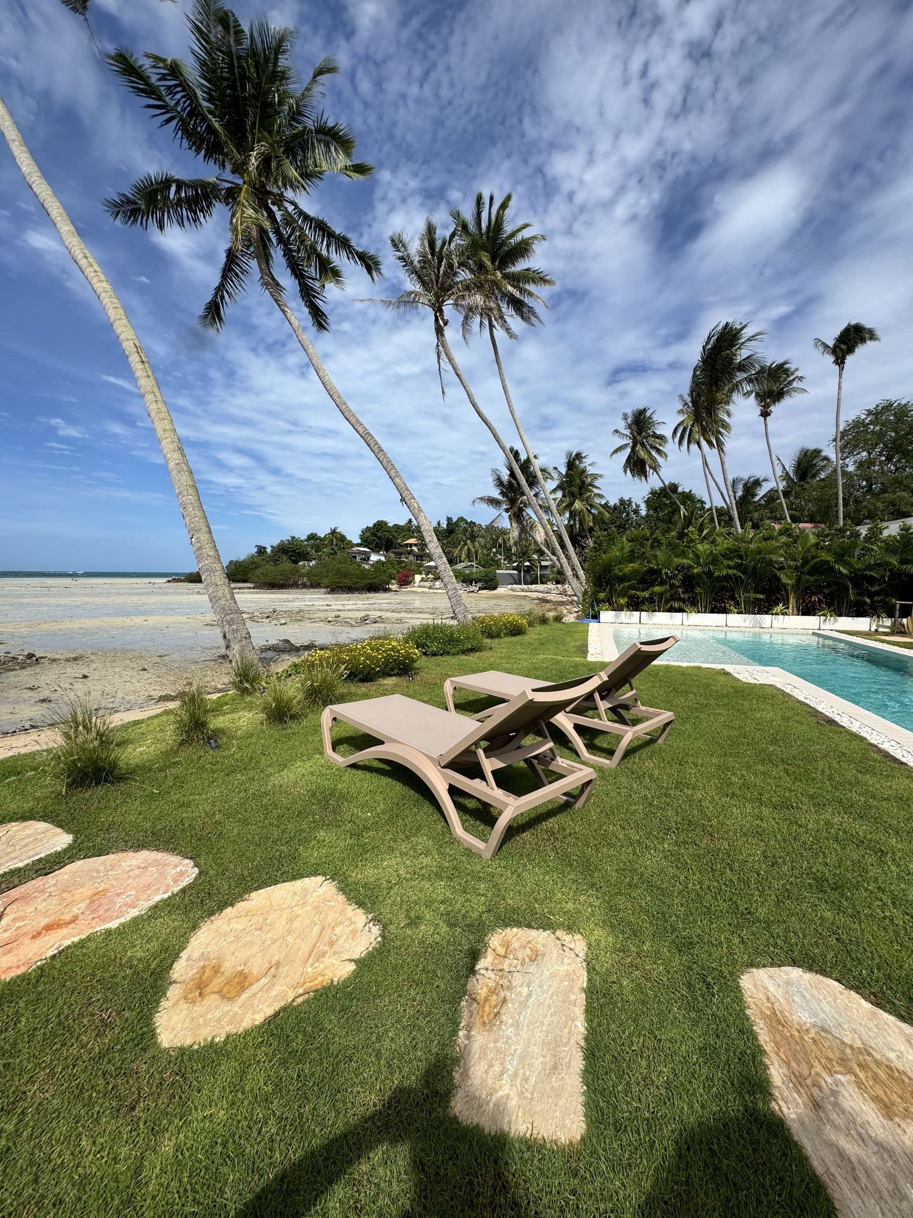 Sun loungers on the lawn where the garden meets Hin Kong Beach