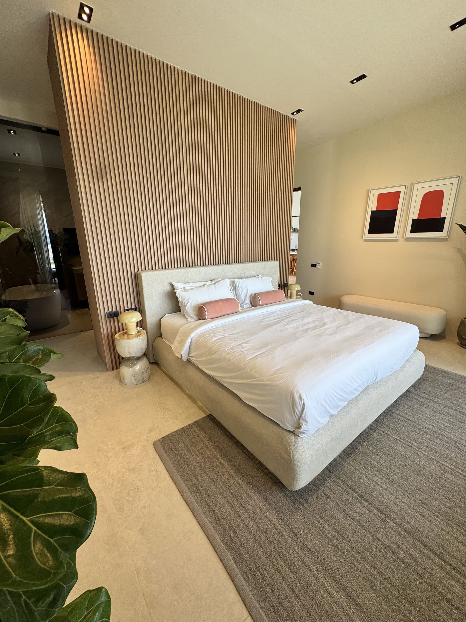 Master bedroom with a king bed and timber headboard wall
